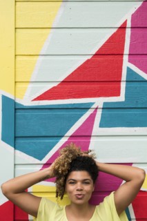 Woman posing against colorful wall