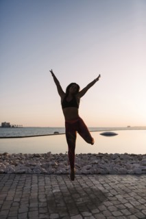Silhouette of woman jumping at sunset