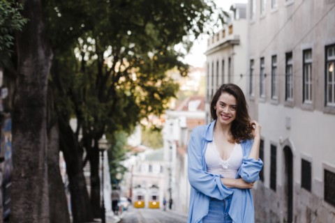 Smiling woman wearing blue coat by building