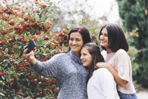 Mother and daughters smiling and taking selfie