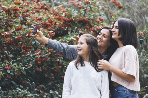 Mother and daughters smiling and taking selfie