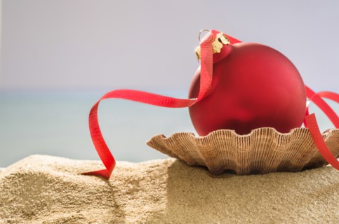 Red bauble on shell on sand