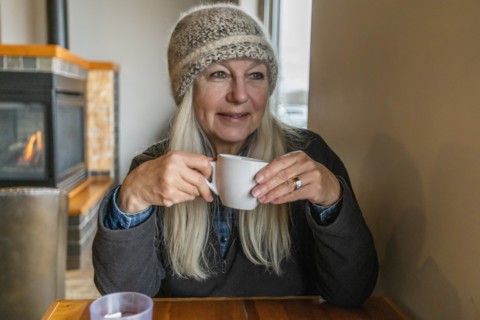 Woman wearing winter clothing holding cup