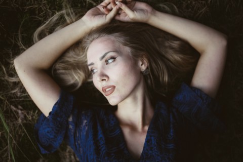 Woman lying down with her arms raised