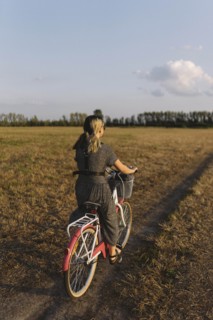 Woman riding bicycle in field