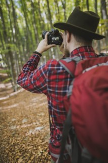 Man taking photograph in forest