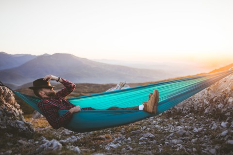 Man sleeping on hammock in mountain range