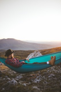 Man lying on hammock in mountain range