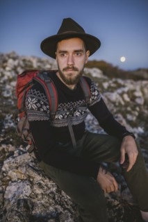 Man sitting on rock at sunset