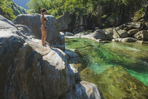 Woman wearing bikini on rock by river