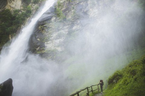 Woman on grass by waterfall