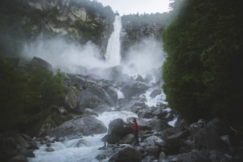 Woman on rocks by waterfall