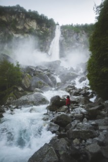 Woman on rocks by waterfall