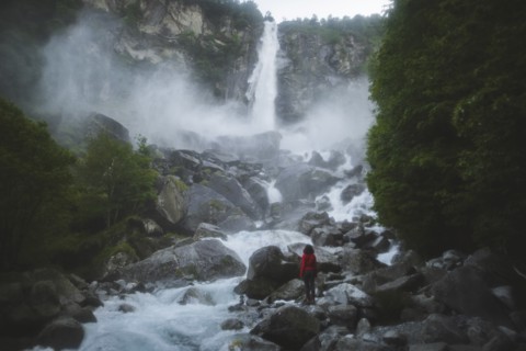 Woman on rocks by waterfall
