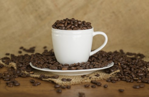 Coffee beans in cup and saucer