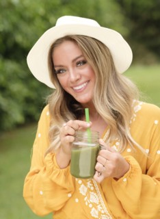 Smiling young woman with smoothie in mason jar