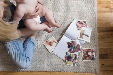 Photographs and book by mother and daughter sitting on rug