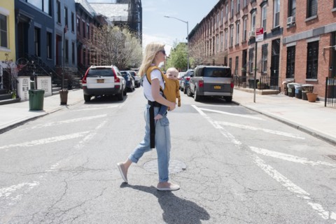 Mother carrying her daughter in baby carrier