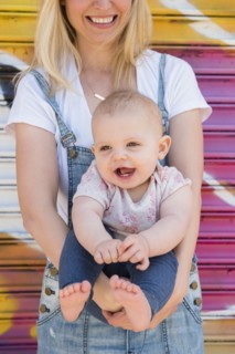 Smiling baby girl being held by her mother