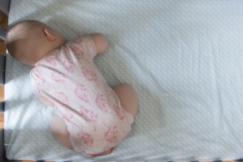High angle view of baby sleeping in crib