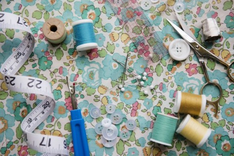 Spools of thread, seam ripper, and measuring tape