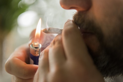 Man lighting marijuana joint