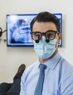 Dentist wearing surgical mask and glasses