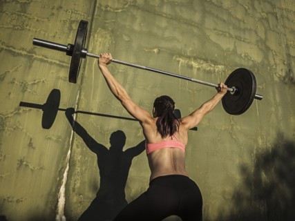 Woman weight lifting with barbell