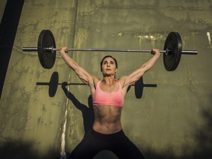 Woman weight lifting with barbell