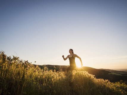 Mid adult woman jogging at sunset