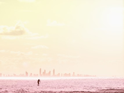Silhouette of man paddleboarding on sea at sunset