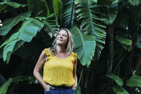 Woman by leaves of palm tree