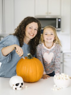 Mother and daughter carving pumpkin for Halloween