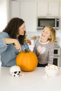 Mother and daughter carving pumpkin for Halloween