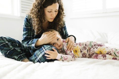 Mother and daughter hugging on bed
