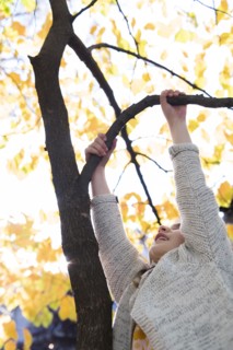 Girl climbing tree during autumn