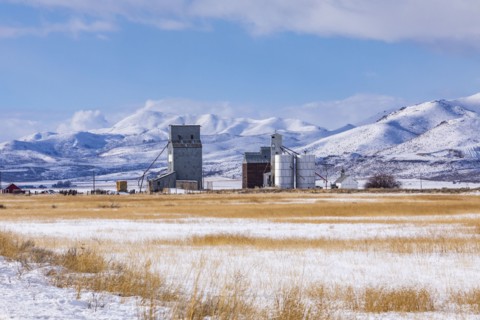 Farm in snowy field by mountains