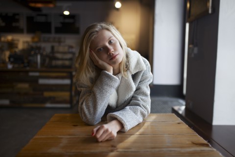young woman sitting at cafe table