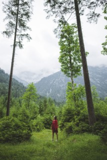 young woman with red jacket in forest