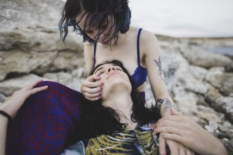 young man lying in woman's lap on beach