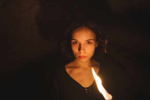 young woman with flaming torch at night
