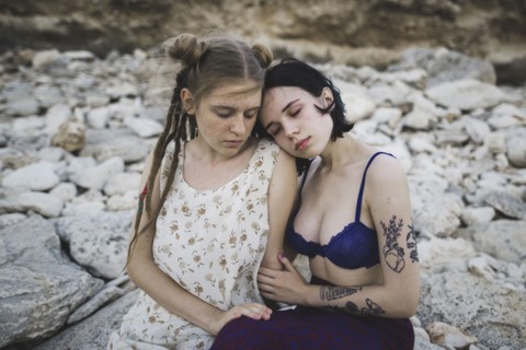 young women sitting together on beach