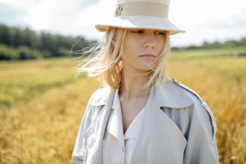 young woman with fedora in wheat field