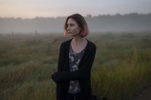 young woman in field at sunset