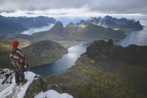 young woman in red hat and sweater on snowy mountain