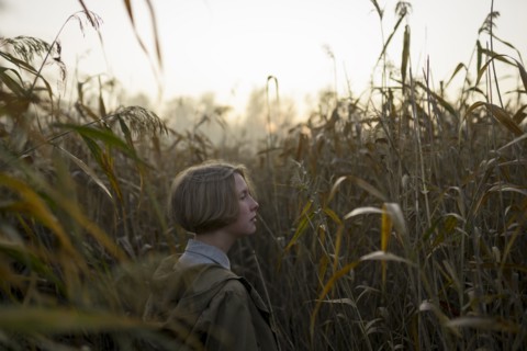 young woman in field of long grass
