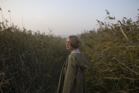young woman in field of long grass