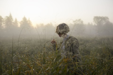 young woman in field of long grass