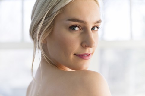 Portrait of woman looking over her bare shoulder