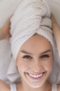 Portrait of smiling woman with head wrapped in towel